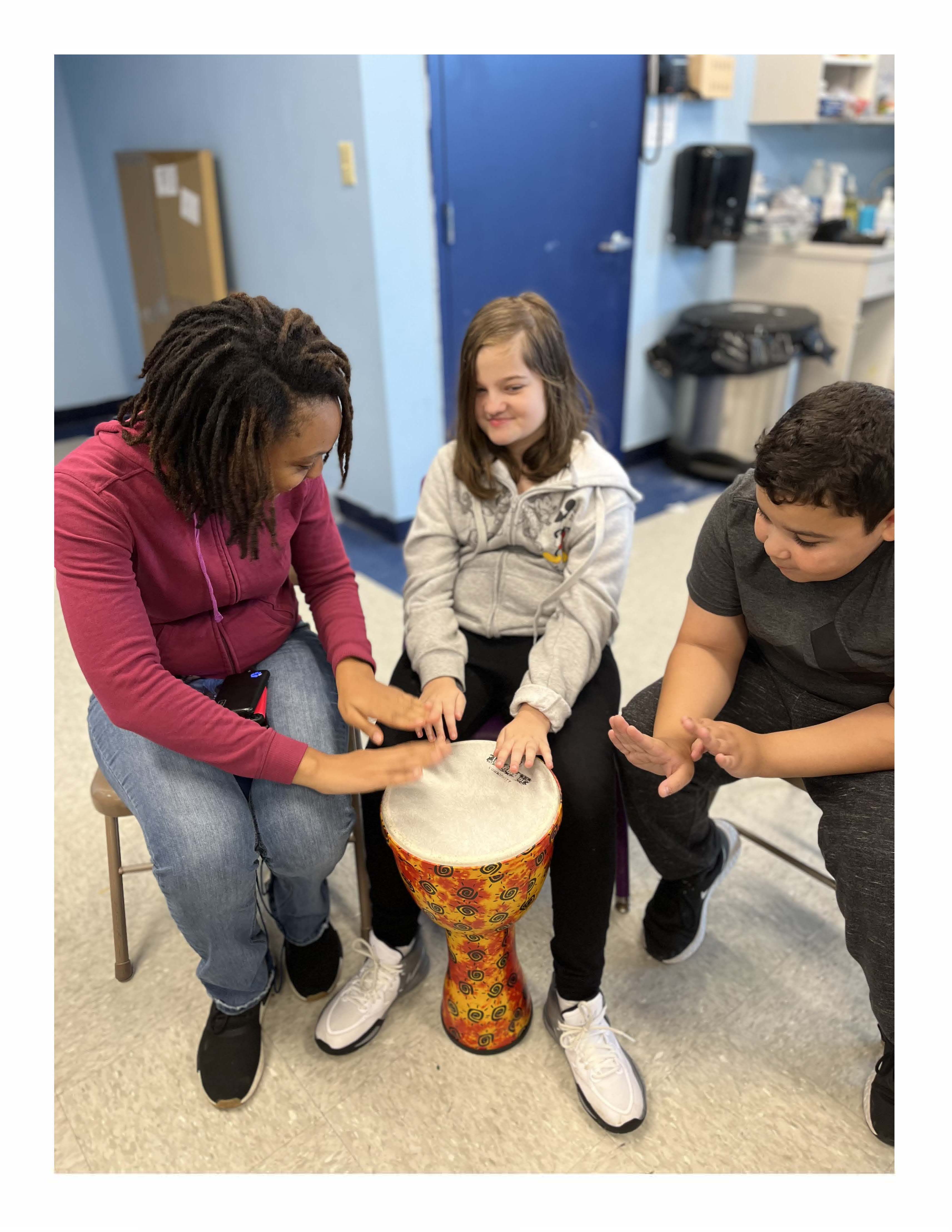 A group of children with developmental disabilities playing with a djembe.
