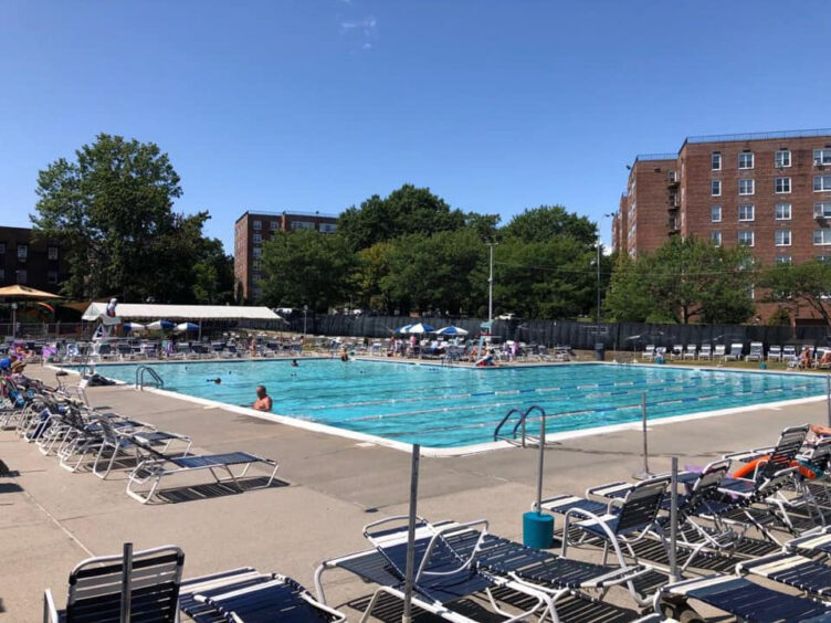 A swimming pool with lounge chairs and umbrellas.