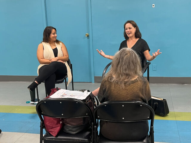 Two women sitting in chairs talking to each other.