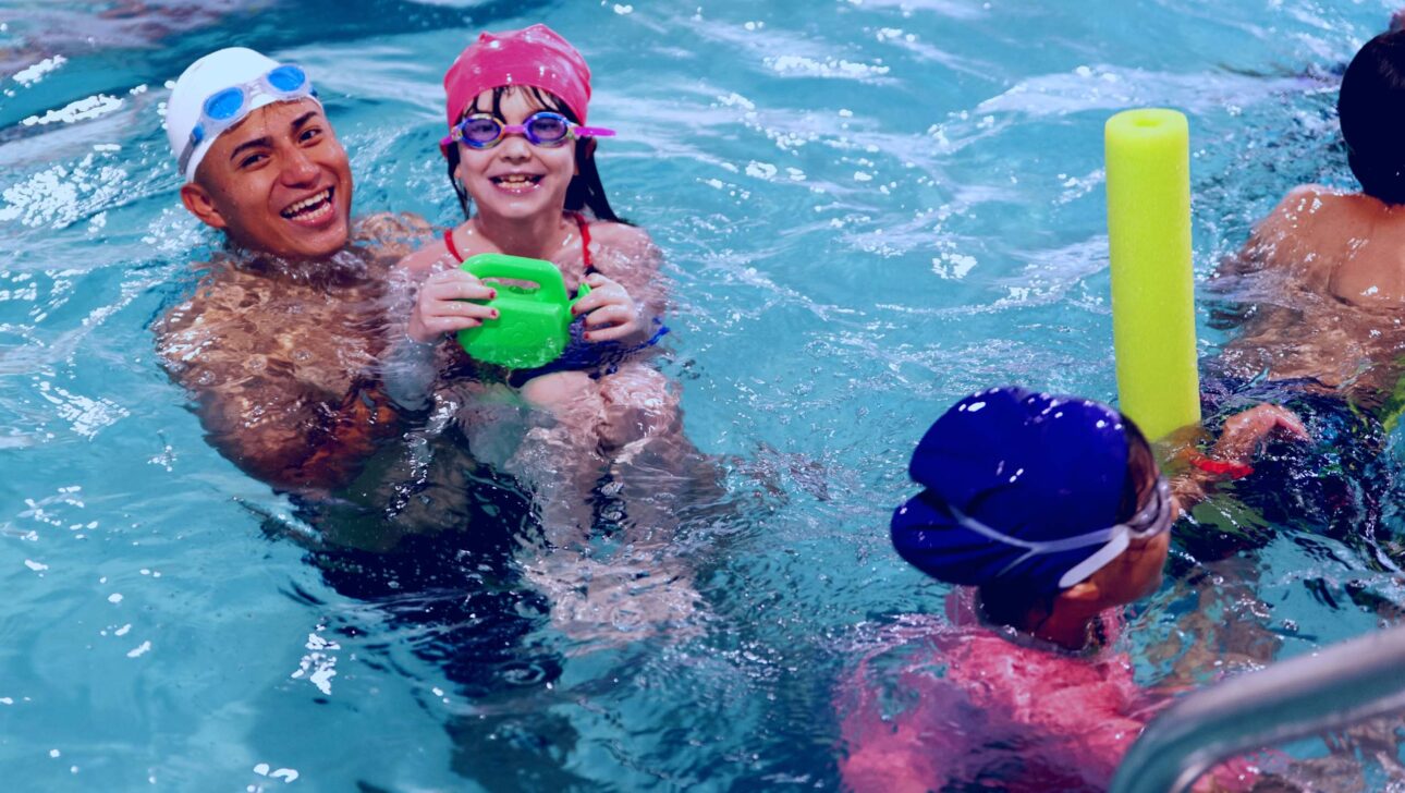 A group of children playing in a swimming pool.