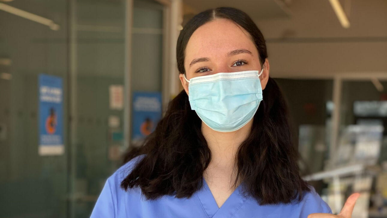 A nurse holding up a cna exam book.