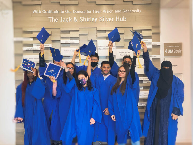 A group of people in blue hats are holding up their hats.