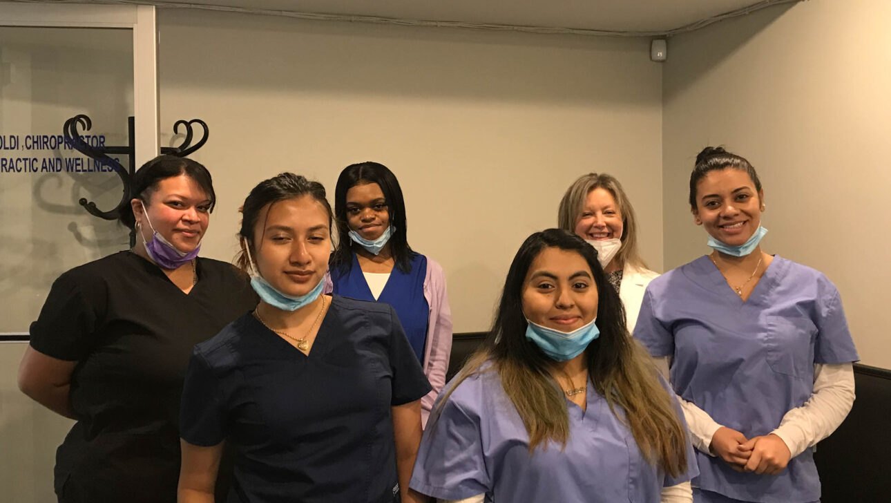 A group of women in scrubs posing for a photo.