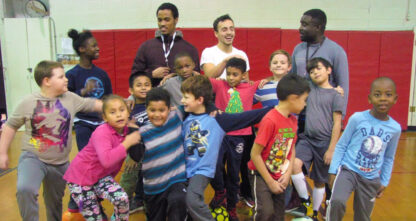 A group of children posing for a picture in a gym.