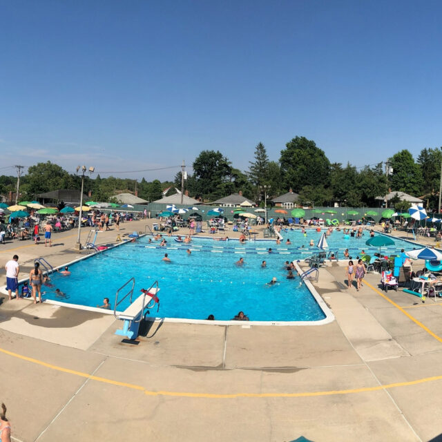 An aerial view of a swimming pool with many people in it.