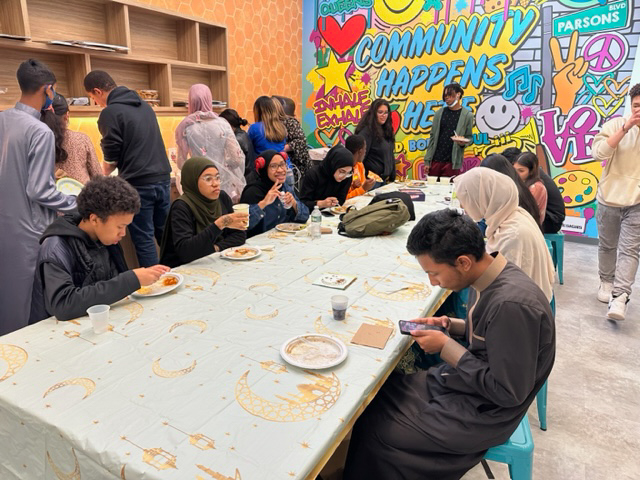 A group of people sitting around a table eating food.
