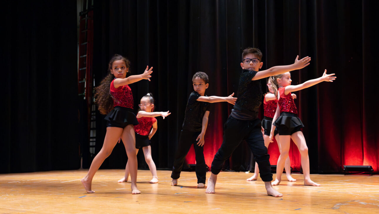 A group of young dancers on a stage.