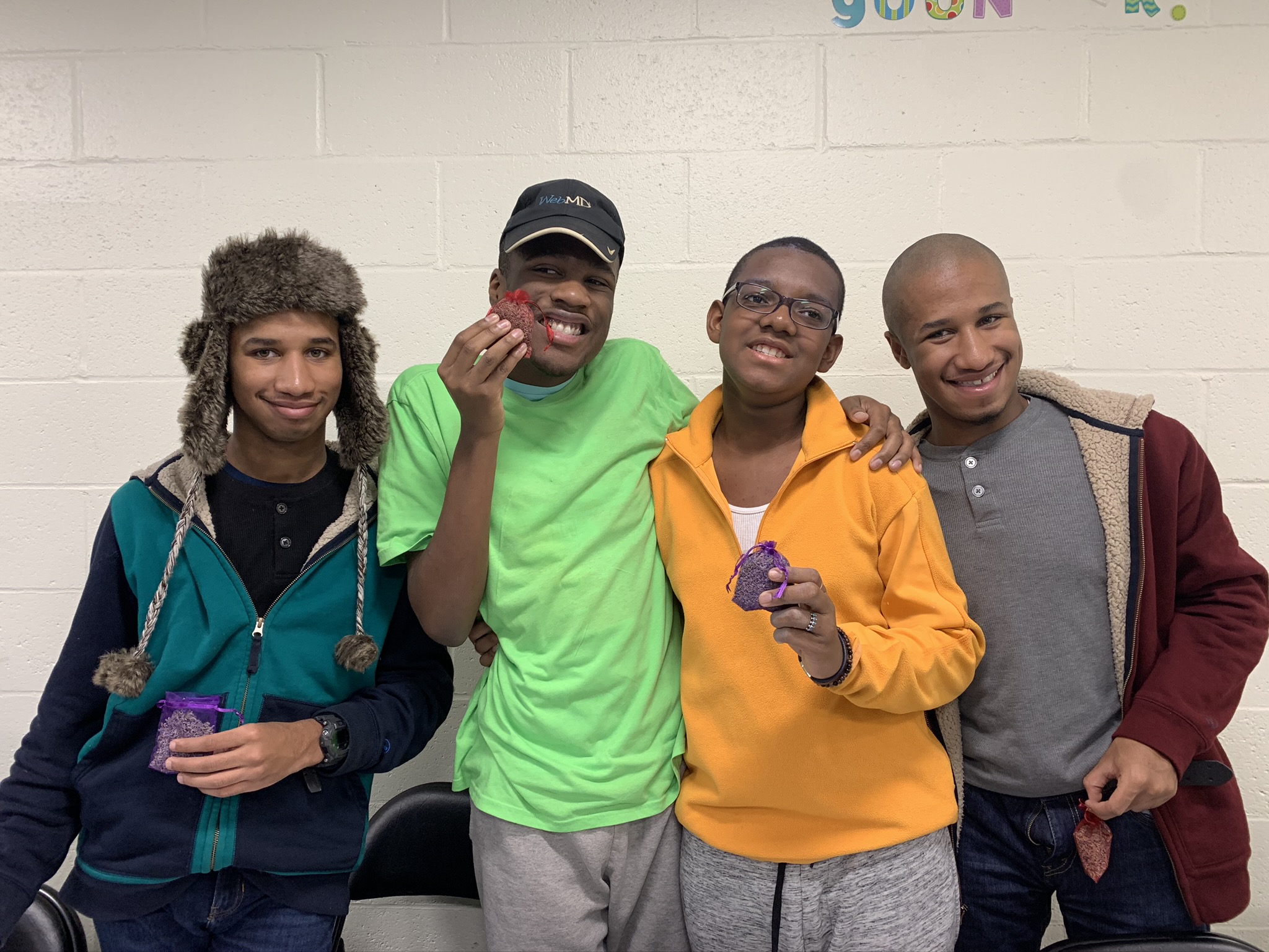 Four youth posing for a photo in a classroom.