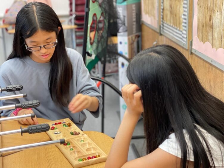 Two girls from MS 172 playing a game of chess in their classroom.