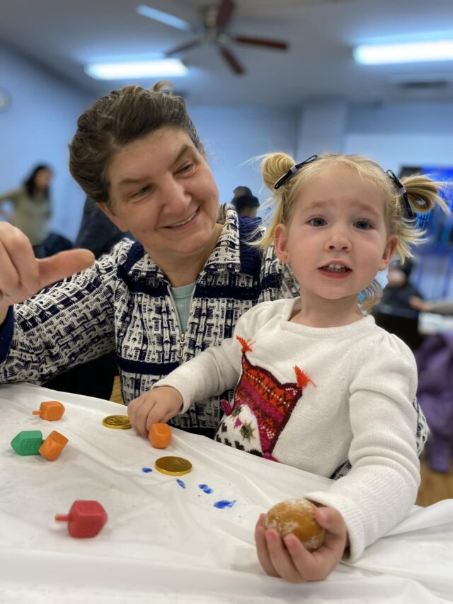 A woman and a little girl engaging in Cultural Arts by playing with dough.