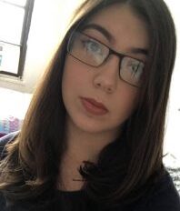 A girl in glasses is taking a selfie, using auto mode.