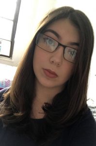 A girl in glasses is taking a selfie, using auto mode.