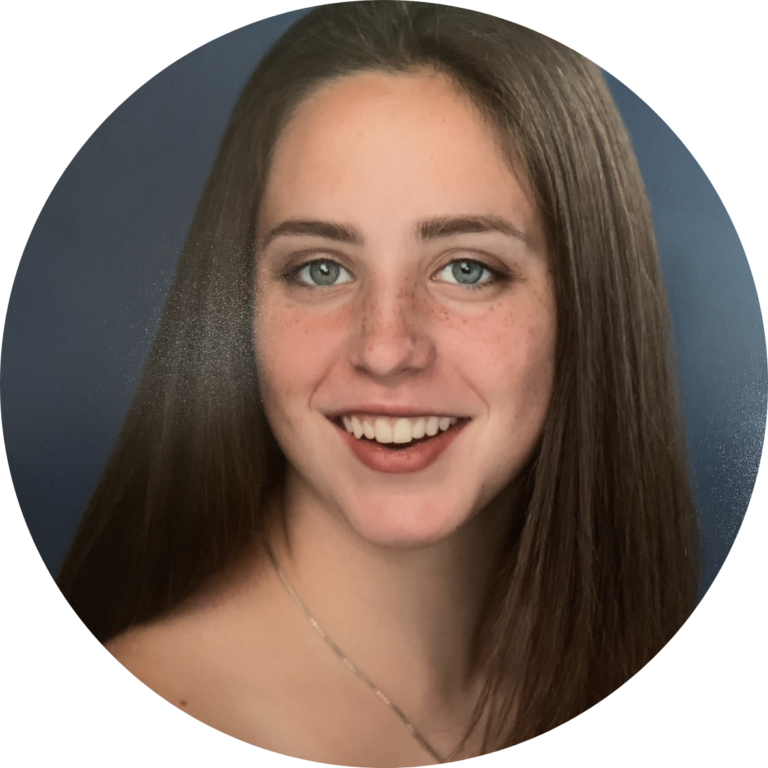 A portrait of Alexis Shapiro, a young woman with brown hair and blue eyes.