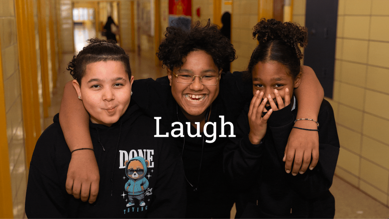 Three children in a school hallway smiling and laughing, with the word "Laugh" overlayed on the image, capturing a joyful after-school moment.