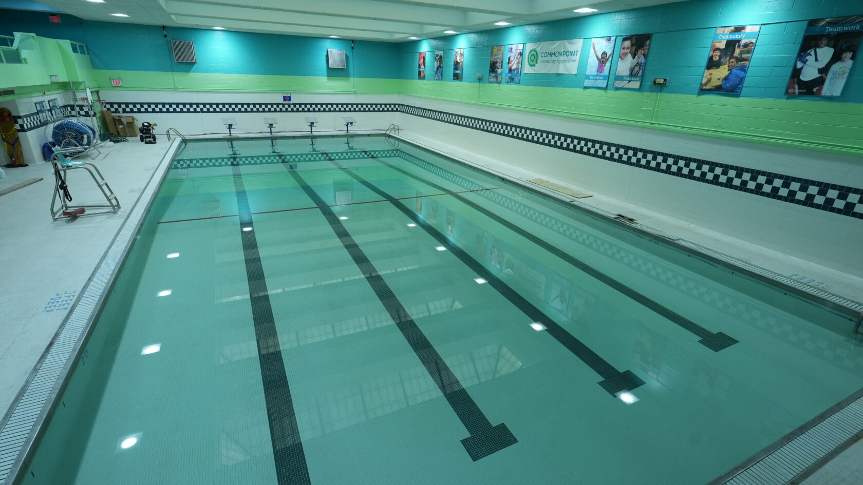 Dive into the aquatic oasis of our indoor swimming pool, featuring turquoise walls and racing lanes. Perfect for swim classes or solo laps, it boasts diving boards and vibrant wall posters, creating a welcoming atmosphere for all swimmers right in the heart of the Bronx.